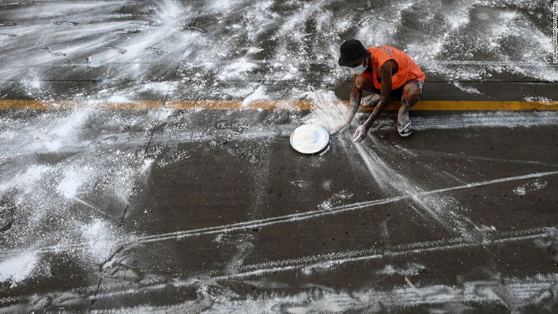 A volunteer in Yangon, Myanmar, spreads calcium oxide on a road to help prevent the spread of the coronavirus on April 22.